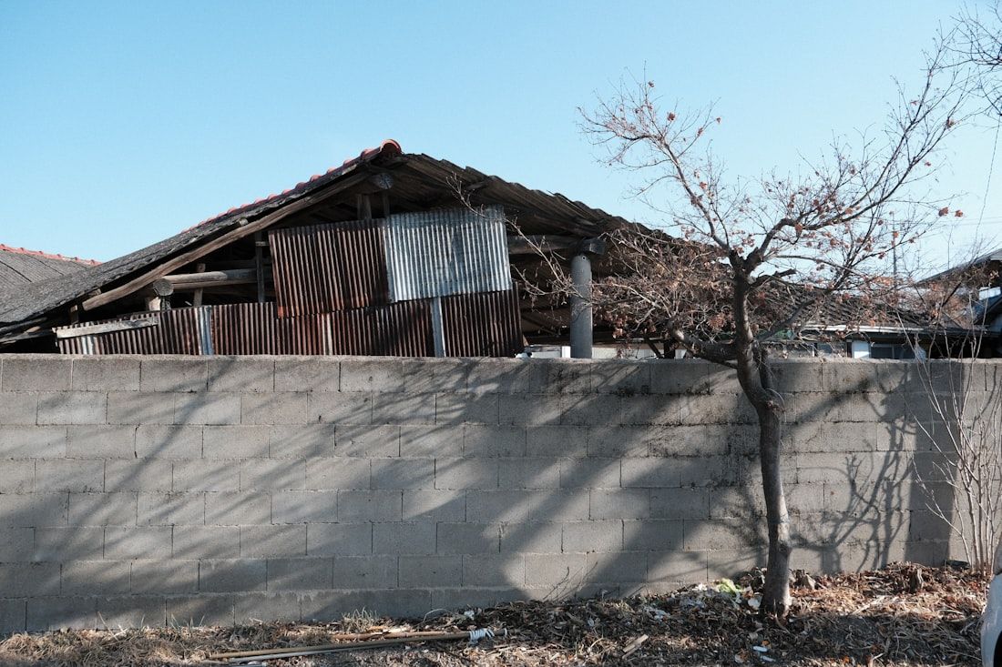 Muro com entulho e material acumulado ao lado