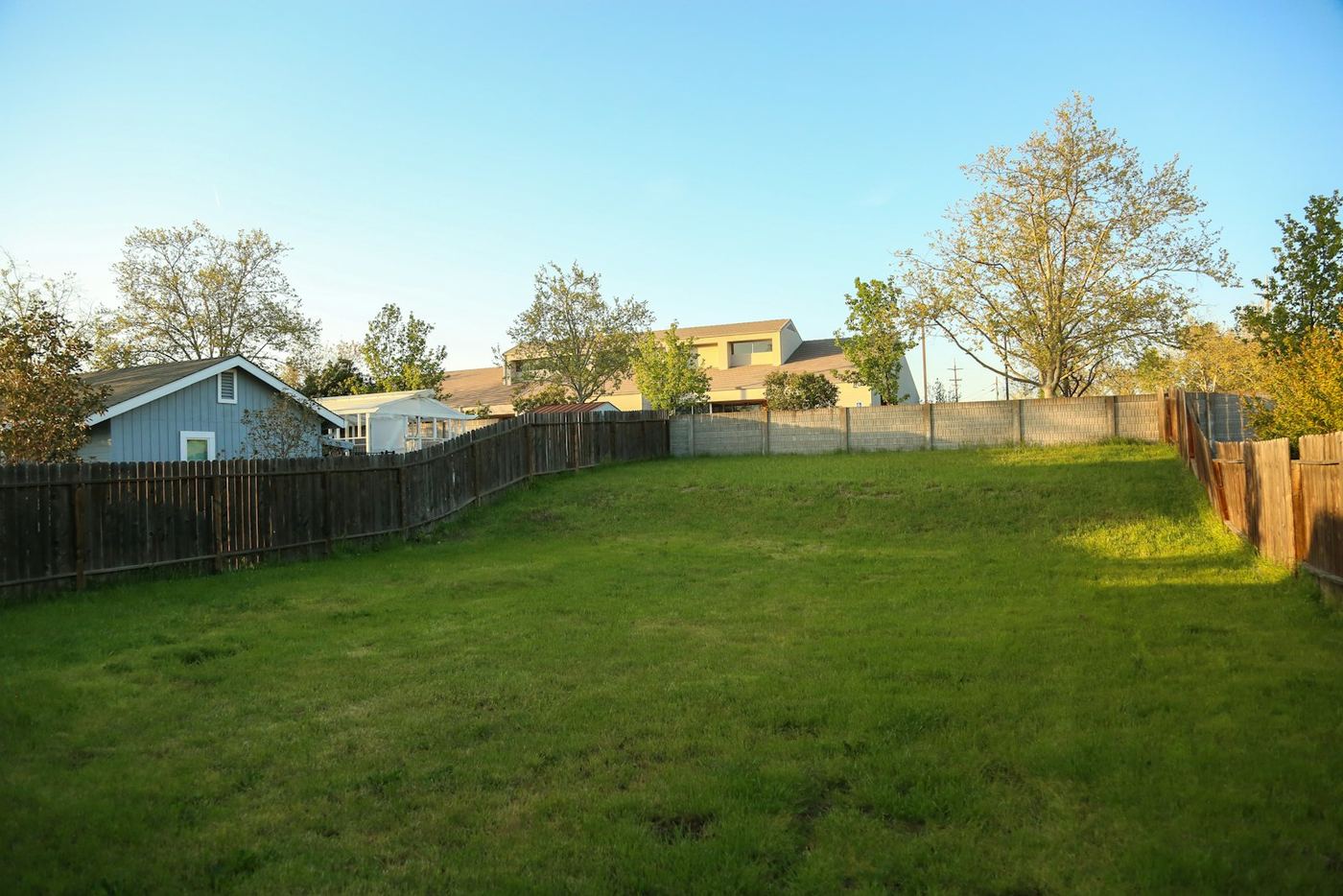 Jardim residencial com gramado e cerca de madeira